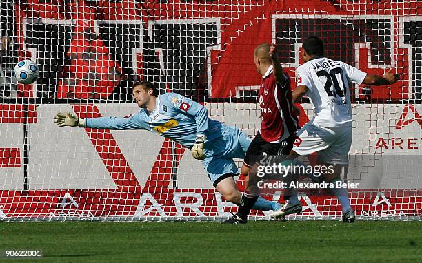 Peer Kluge of Nuernberg scores a goal against goalkeeper Christopher Heimeroth of M'gladbach during the Bundesliga match between 1. FC Nuernberg and...