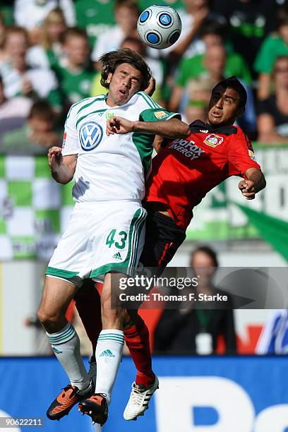 Andrea Barzagli of Wolfsburg and Arturo Vidal of Leverkusen jump for a header during the Bundesliga match between VfL Wolfsburg and Bayer Leverkusen...