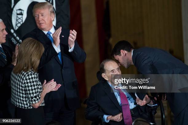 Former Sen. Bob Dole, R-Kan., seated, is greeted by Speaker Paul Ryan, R-Wis., as President Donald Trump, VP Mike Pence, and Rep. Lynn Jenkins,...