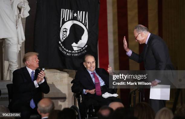 Senate Minority Leader Charles Schumer and President Donald Trump congratulate former Senate Majority Leader Bob Dole on receiving the Congressional...