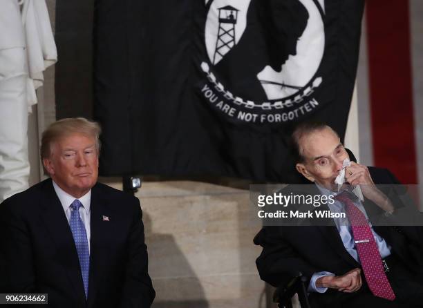 President Donald Trump listens to former Senate Majority Leader Bob Dole speak during a ceremony awarding Dole the Congressional Gold Medal at the...
