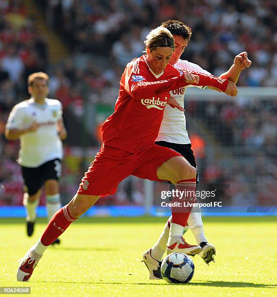 Fernando Torres of Liverpool is tackled by Clarke Carlisle of Burnley during the Barclays Premier League match between Liverpool and Burnley at...