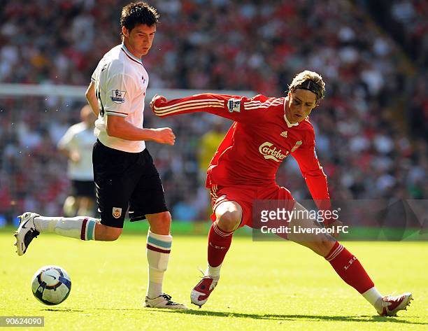 Fernando Torres of Liverpool is challenged by Clarke Carlisle of Burnley during the Barclays Premier League match between Liverpool and Burnley at...