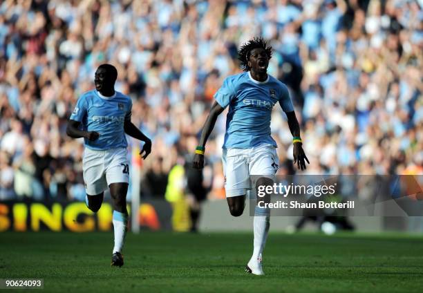 Emmanuel Adebayor of Manchester City runs towards the Arsenal fans as he celebrates scoring with team-mate Kolo Toure during the Barclays Premier...