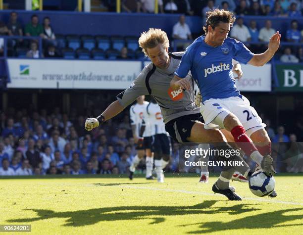 Portsmouth's English striker Tommy Smith tussles with Bolton Wanderers Finnish goalkeeper Jussi Jaaskelainen during their Premier League football...