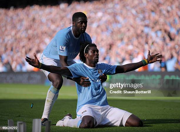 Cigarette lighter is thrown onto the pitch as Emmanuel Adebayor of Manchester City celebrates with team-mate Kolo Toure in front of the Arsenal fans...