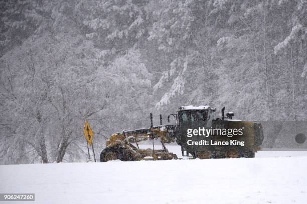 Snow plow moves along Wade Avenue as snow falls on January 17, 2018 in Raleigh, North Carolina. North Carolina Gov. Roy Cooper declared a state of...