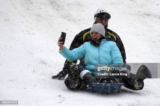 Woman takes a selfie while sledding at Dorothea Dix Park during a snow storm on January 17, 2018 in Raleigh, North Carolina. North Carolina Gov. Roy...