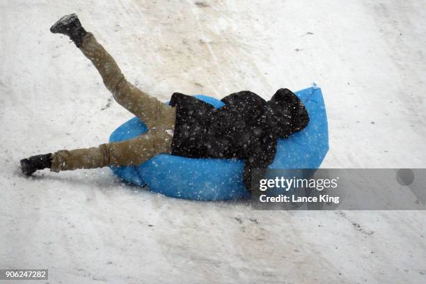 Man crashes while sledding down a hill at Dorothea Dix Park during a snow storm on January 17, 2018 in Raleigh, North Carolina. North Carolina Gov....