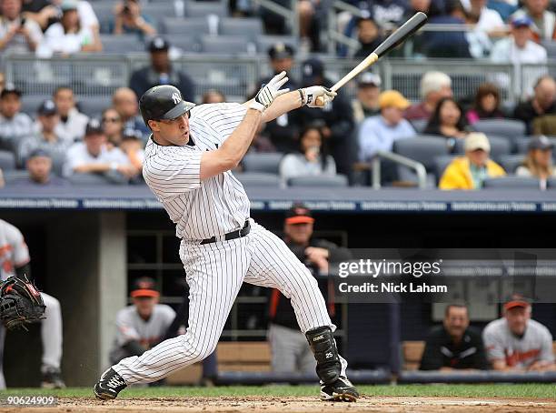 Mark Teixeira of the New York Yankees hits a sacrifice fly to score the run of Derek Jeter in the first inning against the Baltimore Orioles on...