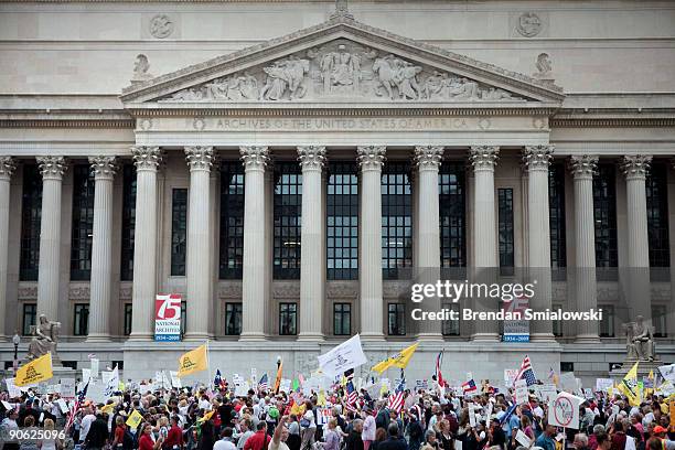 Protesters pass the National Archives during the Tea Party Express rally on September 12, 2009 in Washington, DC. Thousands of protesters gathered in...