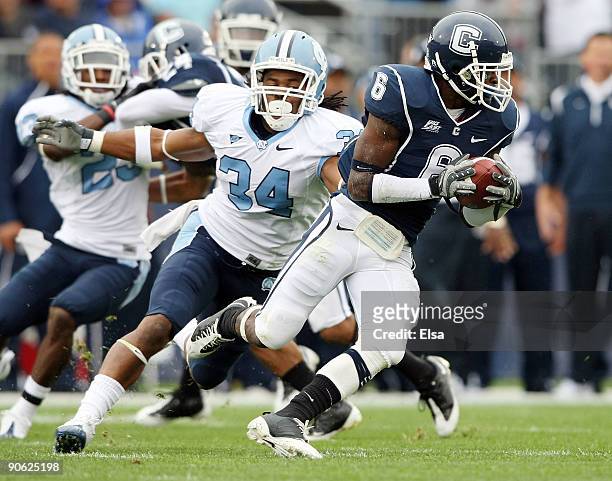 Jasper Howard of the Connecticut Huskies carries the ball as Johnny White of the North Carolinia Tar Heels tries to make the tackle on September 12,...