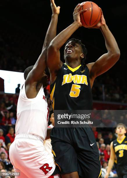 Tyler Cook of the Iowa Hawkeyes takes a shot as Mamadou Doucoure of the Rutgers Scarlet Knights defends during the first half of a game at Rutgers...