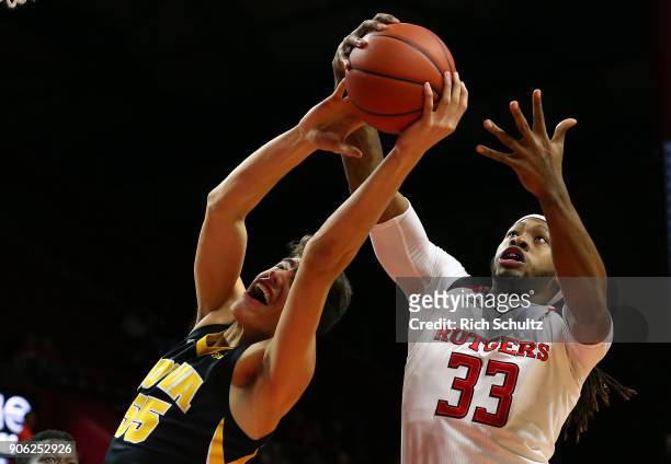 Deshawn Freeman of the Rutgers Scarlet Knights pulls a rebound away from Luka Garza of the Iowa Hawkeyes during the first half of a game at Rutgers...