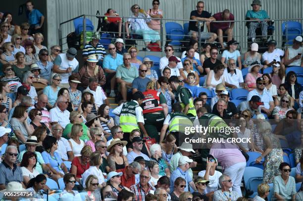 Medical staff attend to a spectator who collapsed during the men's singles second round match between Austria's Dominic Thiem and Denis Kudla of the...