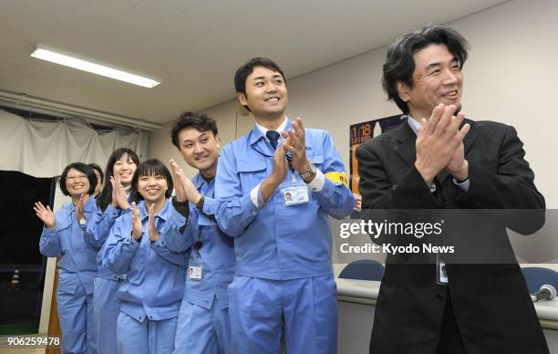 Staff involved in the launch of an Epsilon-3 rocket applaud as it successfully takes off from the Uchinoura Space Center in Kimotsuki, in...