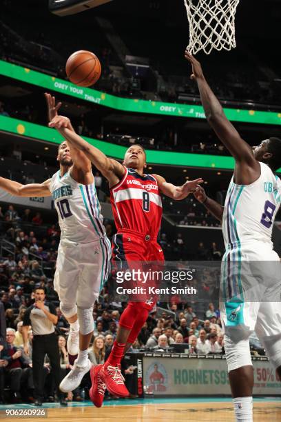 Tim Frazier of the Washington Wizards, Michael Carter-Williams of the Charlotte Hornets, and Johnny O'Bryant III of the Charlotte Hornets compete for...