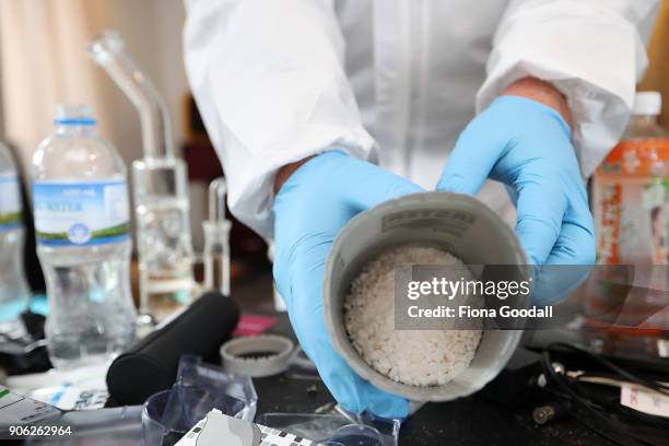 Police officer examines chemicals and equipment found in a methamphetamine manufacturing lab following a police raid on January 17, 2018 in Auckland,...