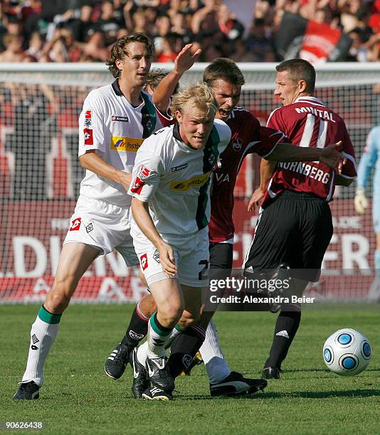 Christian Eigler of Nuernberg fights for the ball with Tobias Levels and Roel Brouwers of M'gladbach as Marek Mintal of Nuernberg watches them during...