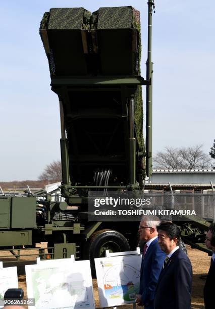 Visiting Australian Prime Minister Malcolm Turnbull and Japanese Prime Minister Shinzo Abe listen to a briefing on the PAC-3 surface-to-air missile...