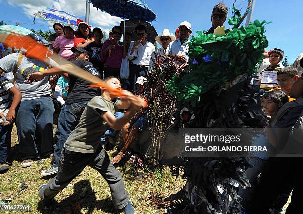 The son of a supporter of ousted Honduran President Manuel Zelaya beats a "pinata" representing the Chief of General Staff Romeo Vasquez Velazquez...