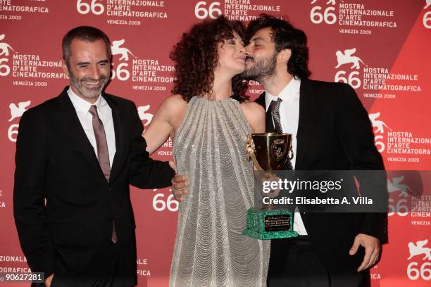 Actress Kseniya Rappoport holds her Best Actress award and receives a kiss from actor Filippo Timi next to director Giuseppe Capotondi during the...