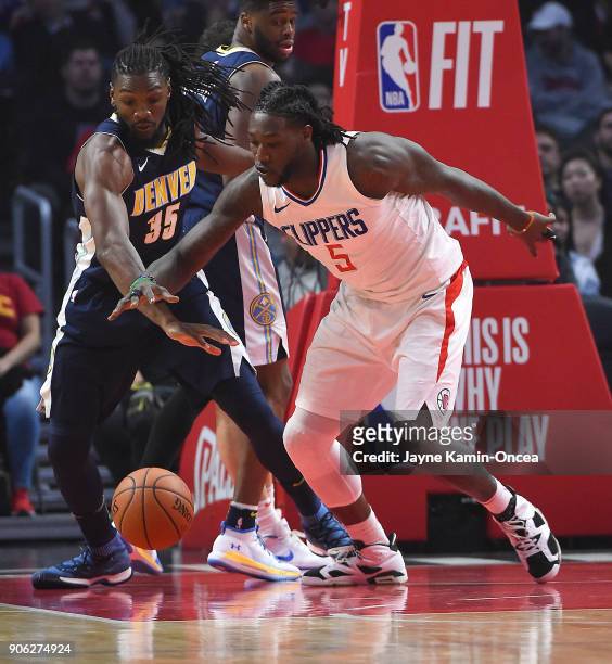 Montrezl Harrell of the Los Angeles Clippers and Kenneth Faried of the Denver Nuggets chase down a loose ball in the first half of the game at...