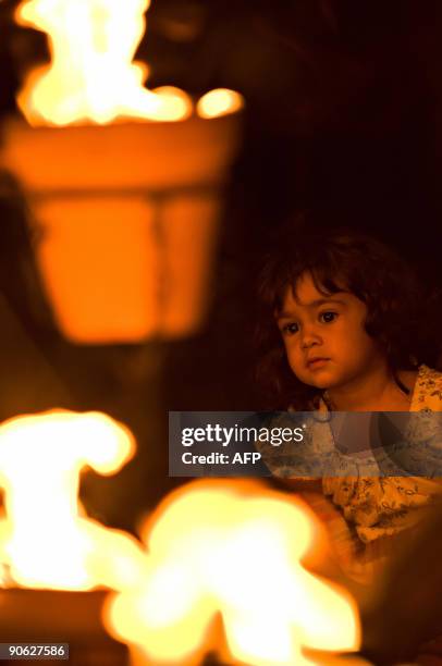 Anoushka, aged 2, looks at a sculpture as the "Fire Garden" designed by French fire masters Compagnie Carabosse is opened to the public outside the...