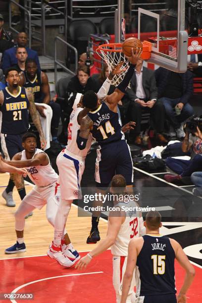 Denver Nuggets Guard Gary Harris is defended by Los Angeles Clippers Center Willie Reed going up for a dunk during an NBA game between the Denver...