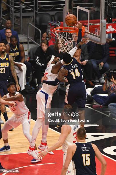 Denver Nuggets Guard Gary Harris is fouled hard by Los Angeles Clippers Center Willie Reed going up for a dunk during an NBA game between the Denver...