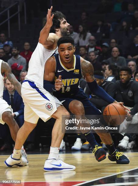 Milos Teodosic of the Los Angeles Clippers guards against Gary Harris of the Denver Nuggets as he drives to the basket in the first half of the game...