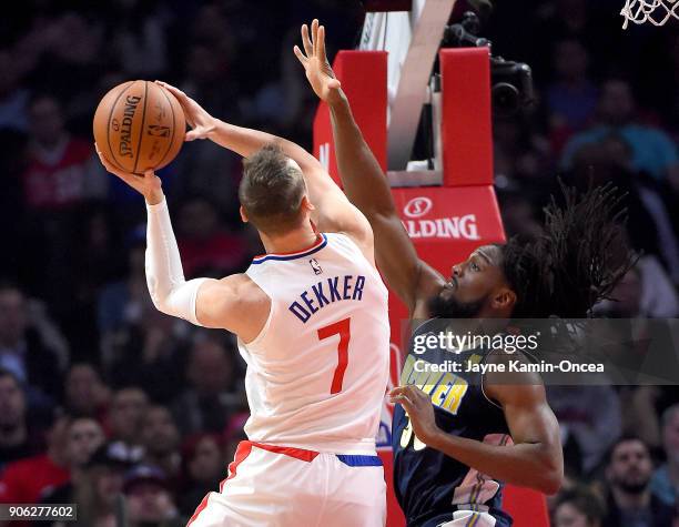 Kenneth Faried of the Denver Nuggets defends a shot by Sam Dekker of the Los Angeles Clippers in the first half of the game against the Denver...