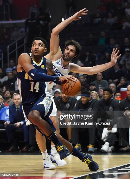 Milos Teodosic of the Los Angeles Clippers guards against Gary Harris of the Denver Nuggets as he drives to the basket in the first half of the game...