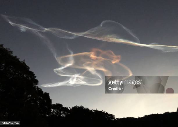 Smoke trails made by an Epsilon rocket are seen during the morning sunrise over Kimotsuki town in Kagoshima prefecture on January 18, 2018. The...