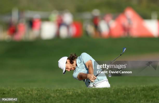 Tommy Fleetwood of England plays his second shot on the par 4, 14th hole during the first round of the 2018 Abu Dhabi HSBC Gof Championship at the...