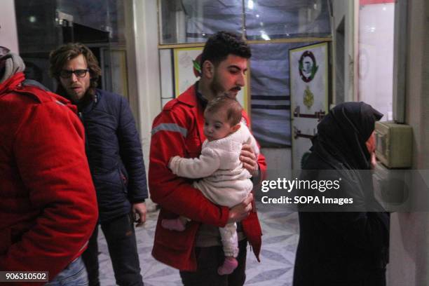 Medical personal seen carrying a infant as they returned from the besieged town of Douma. Five children with serious illnesses returned to the...