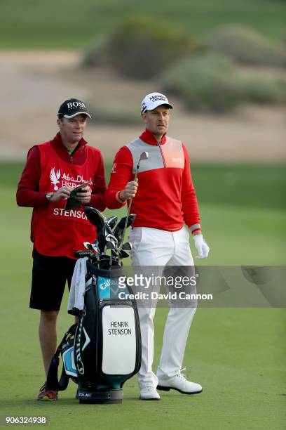 Henrik Stenson of Sweden wiats to play his second shot on the par 5, 10th hole with his caddie Gareth Lord during the first round of the 2018 Abu...