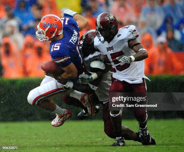 Tim Tebow of the Florida Gators is tackled by Barry Valcin and Cameron Sheffield of the Troy Trojans during the game at Ben Hill Griffin Stadium on...