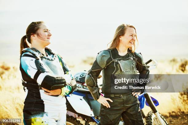 laughing friends in discussion while resting during desert dirt bike ride - chest protector stock pictures, royalty-free photos & images