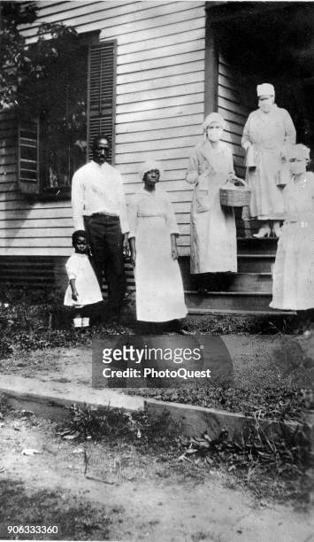 Portrait of an unidentified family , where the mother had died from flu-related causes, as they are visited by a trio of American Red Cross workers,...