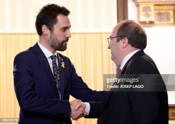 Newly elected Catalan parliament speaker Roger Torrent shakes hands with Catalan Socialist Party leader, Miquel Iceta prior to holding a meeting at...