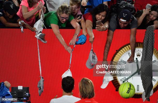 Switzerland's Roger Federer signs autographs for supporters as he celebrates after victory over Germany's Jan-Lennard Struff during their men's...