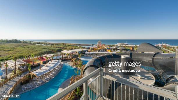 swimming pool with water slides in a luxury tropical hotel resort - water slide stock pictures, royalty-free photos & images