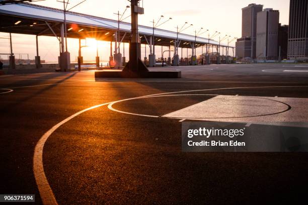 the sun sets behind the basketball courts at pier two in brooklyn bridge park, new york - brooklyn bridge park stock pictures, royalty-free photos & images