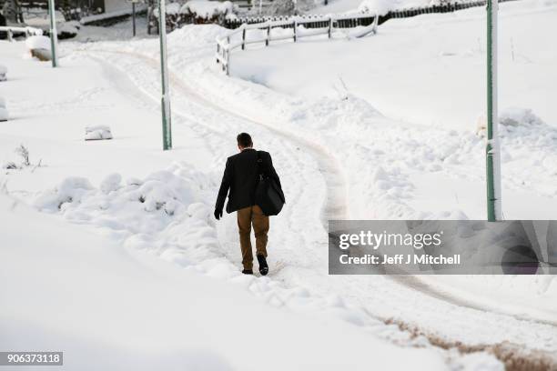Man walks down a road, following extensive snowfall during the last forty eight hours on January 18, 2018 in Leadhills, Scotland. Motorists are being...
