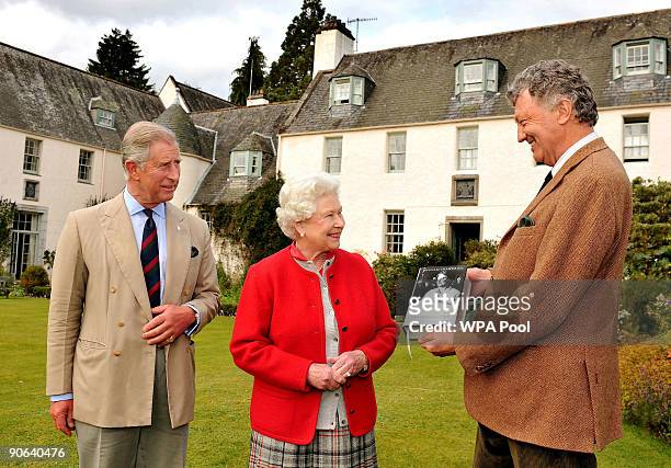 Queen Elizabeth II with Prince Charles, Prince of Wales is presented with one of the first copies of 'Queen Elizabeth the Queen Mother, The Official...