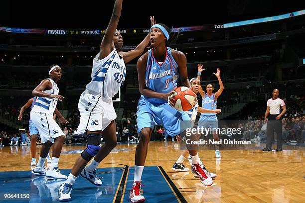 Michelle Snow of the Atlanta Dream drives against Nakia Sanford of the Washington Mystics at the Verizon Center on September 12, 2009 in Washington,...