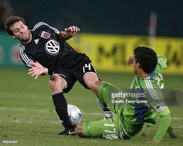 Ben Olsen of D.C. United is tackled hard by Fredy Montero of Seattle Sounders FC during an MLS match at RFK Stadium on September 12, 2009 in...