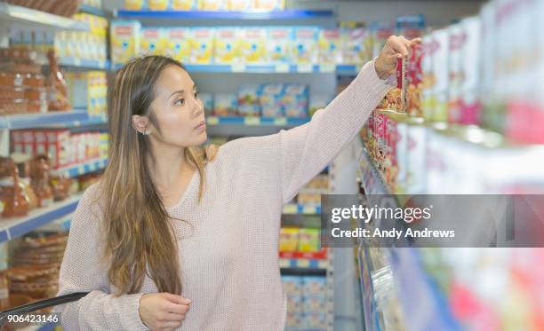 young woman shopping in a grocery store - andy andrews stock-fotos und bilder
