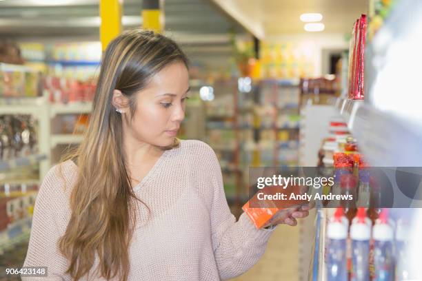 young woman shopping in a grocery store - andy andrews stock-fotos und bilder